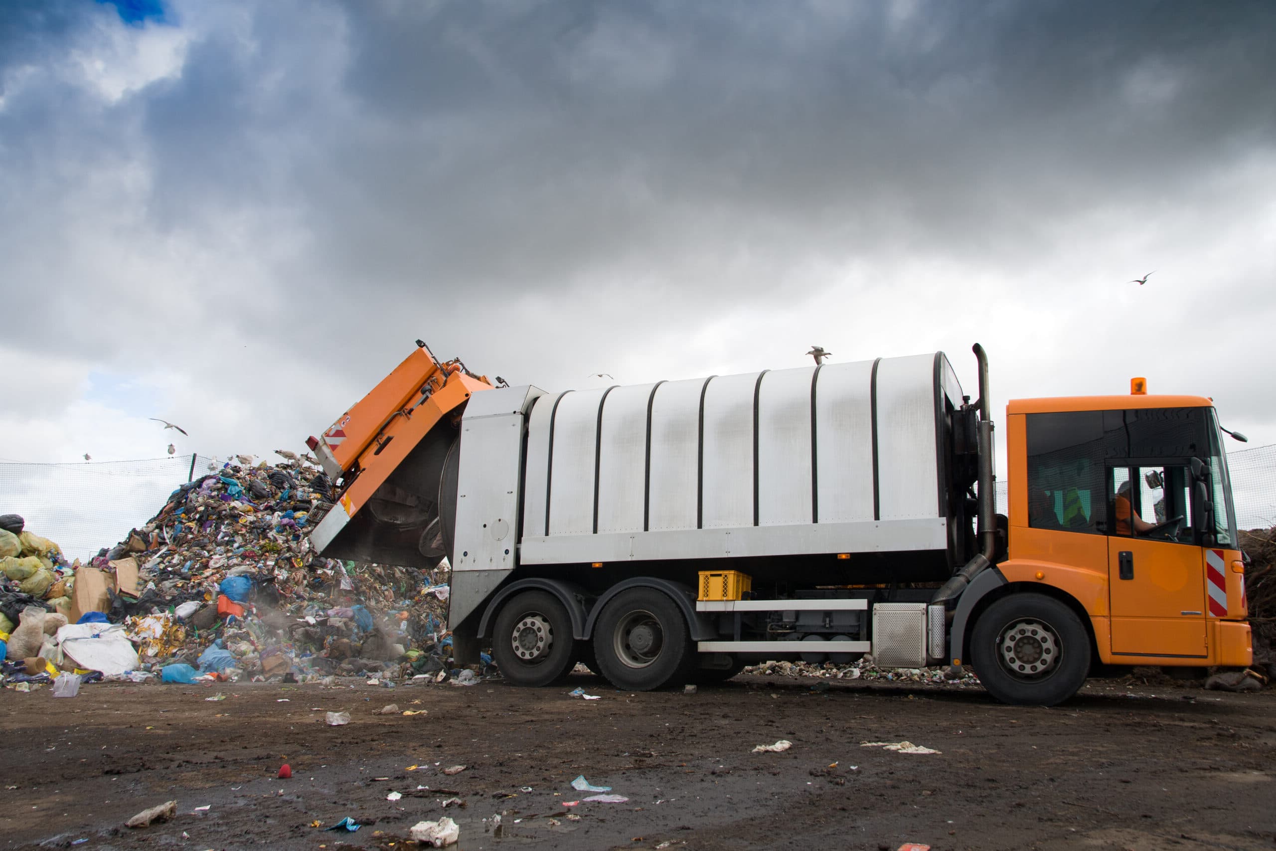 Dump truck unloading dirt and gravel at a job site